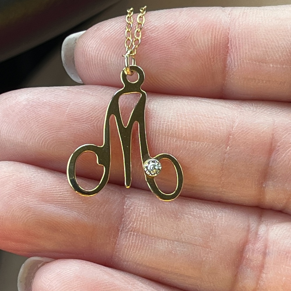 This M charm necklace with diamond chip is 14kt gold plated. New never used